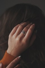 сложное драгоценное кольцо на руке у девушки в волосах