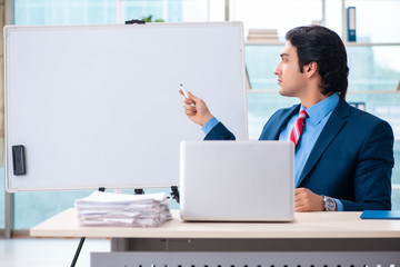 Young handsome businessman in front of whiteboard 