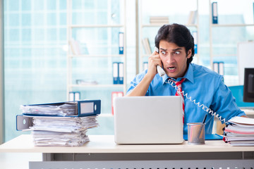 Handsome businessman unhappy with excessive work in the office 