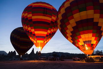 the balloons get ready to departure in Cappadocia from Turkey. People watch them in morning times.