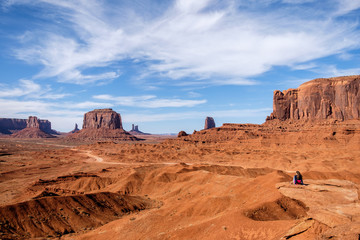 Sitting woman admiring the view of the Monument Valley (Arizona and Utah, USA)