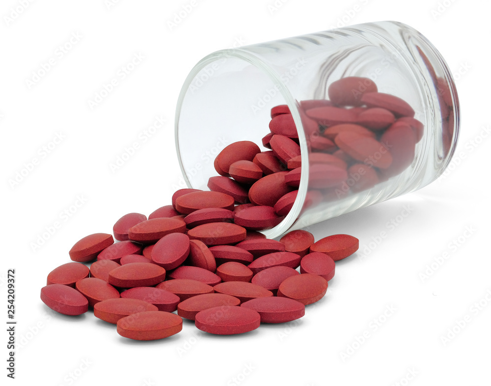 Wall mural Ferrous Fumarate pharmaceutical medicine pills spilling out from cup of pills isolated on white background with clipping path.