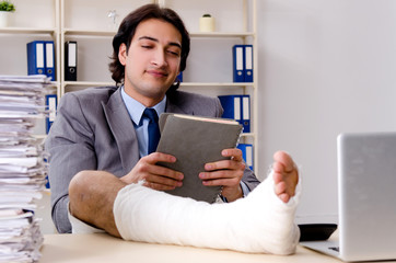 Leg injured employee working in the office 
