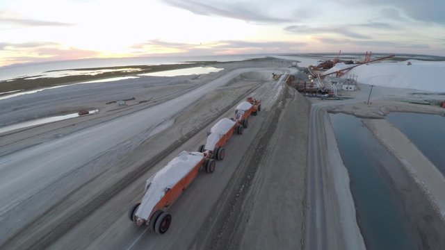 Aerial drone shot of a large truck before unloading the salt salt in the salt flats by solar evaporation in Guerrero Negro, Ojo de Liebre lagoon, Biosphere Reserve of El Vizcaino, Baja California Sur.