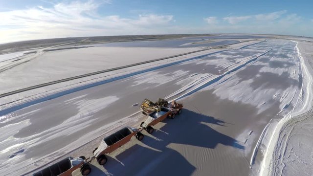 Aerial shot of a large truck being filled with salt in the salt flats by solar evaporation in Guerrero Negro, Ojo de Liebre lagoon, Biosphere Reserve of El Vizcaino, Baja California Sur.
