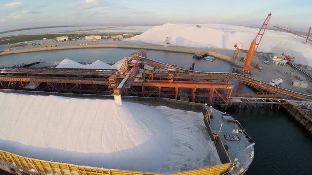 Aerial shot of a large barge being filled with salt in the salt flats by solar evaporation in Guerrero Negro, Ojo de Liebre lagoon, Biosphere Reserve of El Vizcaino, Baja California Sur.
