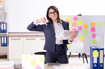 Young female employee in conflicting priorities concept 