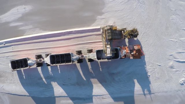Aerial cenital plane shot of a large truck being filled with salt in the salt flats by solar evaporation in Guerrero Negro, Ojo de Liebre lagoon, Biosphere Reserve of El Vizcaino, Baja California Sur