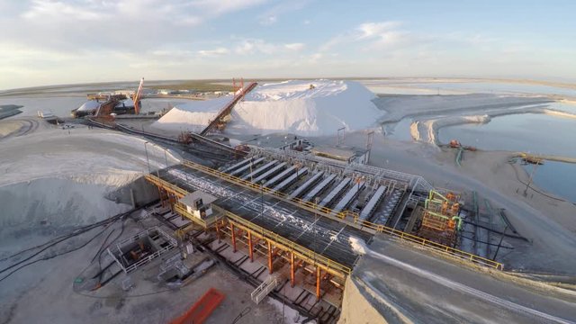 Aerial shot of tractors working on a large salt deposit in the salt flats by solar evaporation in Guerrero Negro, Ojo de Liebre lagoon, Biosphere Reserve of El Vizcaino, Baja California Sur.
