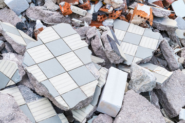 Building debris heap from broken tiles, bricks and concrete. Construction waste pieces close-up....