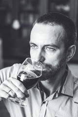 Man tasting freshly brewed beer. Black and white image. Selective focus.