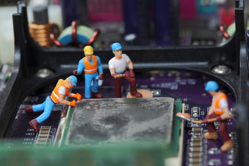 Selective focus of miniature foreman controlling engineer worker to fixed problem and repair Control Processing Unit (CPU),  mainboard computer as industry concept.