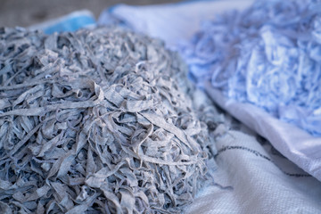 Fabric scraps, old clothing and textiles are cut into strips waiting for recycle.