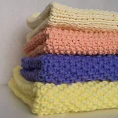 Photo of folded knitted blankets in a pile; handmade; knitting