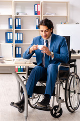 Male employee in wheelchair working at the office 