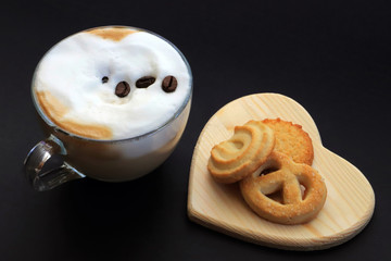CAPPUCCINO E BISCOTTI SU SFONDO NERO, CAPPUCCINO AND BISCUITS ON BLACK BACKGROUND