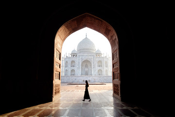 Young woman walking with view of the Taj Mahal, Agra, India - obrazy, fototapety, plakaty