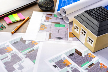 Drawings, layout of the house, documents, calculator on the desktop in the office. Engineering, construction, business.