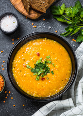 Red lentil soup on black top view.