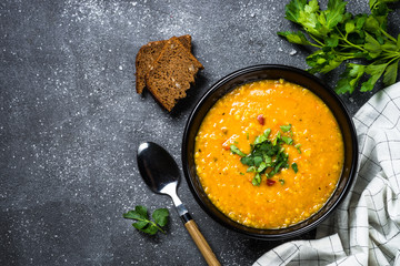 Red lentil soup on black top view.