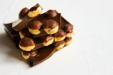 Hazelnut dark chocolate pieces tower on white background.
