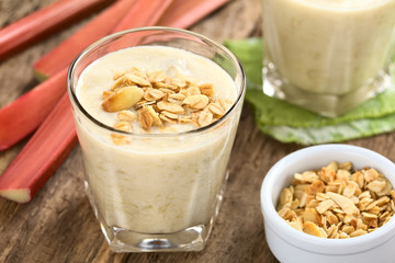 Refreshing rhubarb and yogurt smoothie topped with homemade oatmeal and almond granola and served...