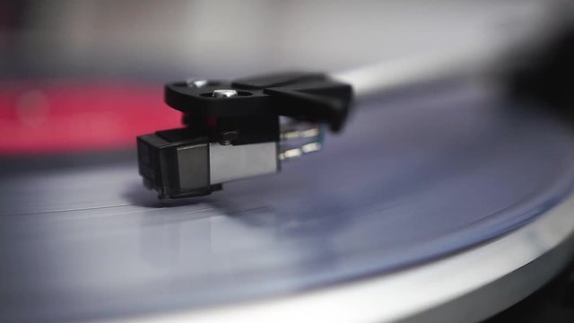 Clear vinyl spinns on the turntable, the headshell drops down on the vinyl and the record begins to play