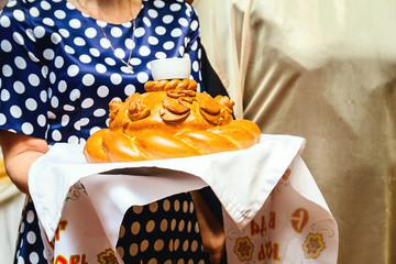 large Russian baked loaf in the women's hands. Wedding loaf