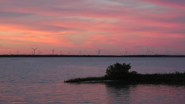 Time lapse sunset at Nueces Bay overlooking a wind farm