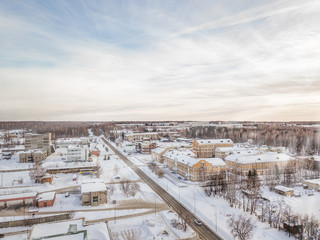 Obraz premium Winter landscape from a aerial view of the city of Novosibirsk in the haze with streets, small buildings, covered by snow and road crossed at the sunset wth bue sky