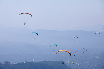 Flying on a paraglider. Beautiful view with mountains and colorful paragliders. Extreme vacation travel