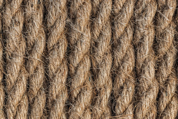 A beautiful horizontal pattern texture from yellow natural flax rope on dark background