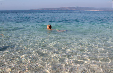 Obraz premium the little girl is swimming in the crystal clear sea. Croatia