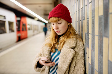 junge Frau wartet in einer U-Bahn Station auf den Zug