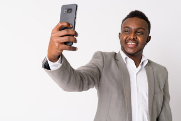 Portrait of happy young African businessman taking selfie