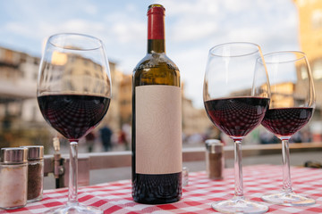 Closeup of bottle red wine and glasses on table of restaurant