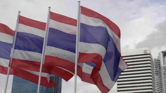 The Kingdom of Thailand flags waving in the wind in front superstructure. Multiple flags waves in the wind.