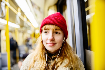 junge Frau mit Smartphone fährt mit der U-Bahn