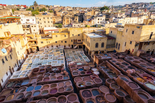 FES, MOROCCO - NOVEMBER 15, 2018:  Dye reservoirs in tannery in ancient medina Fes, Morocco, where the world famous moroccan leather is being made. Colored dye reservoirs and vats in a traditional tan