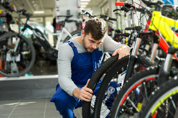 professional man checking tire on wheel