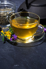 tea with aromatic herbs on a dark background, vertical