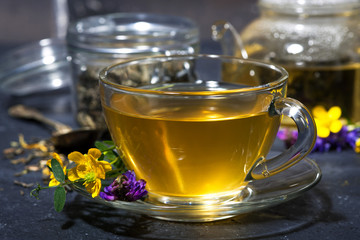 tea with aromatic herbs on a dark table, closeup
