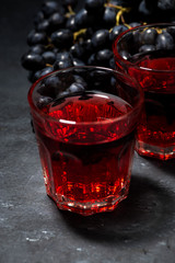 two glasses of red young wine on a dark table, closeup
