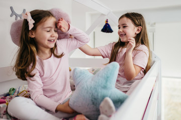 Fototapeta premium Cute little sisters playing in children's room.