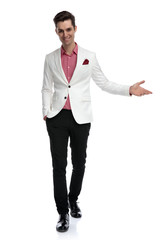 smiling young elegant man invites while walks