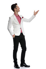 side view of a young elegant man showing something up