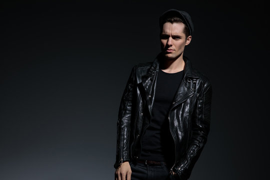 young fashion man in leather jacket looking upset