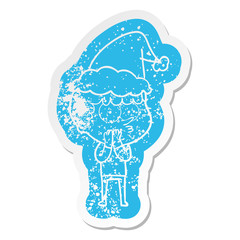 cartoon distressed sticker of a curious boy wearing santa hat