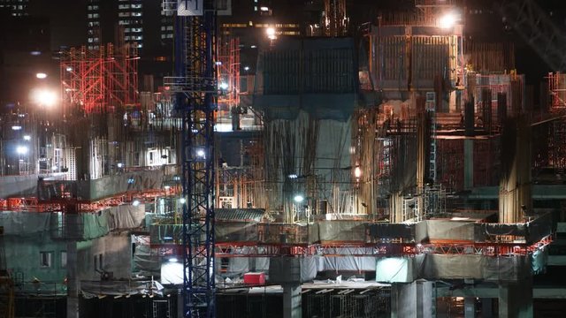 Time lapse builders and cranes working on the construction site close-up