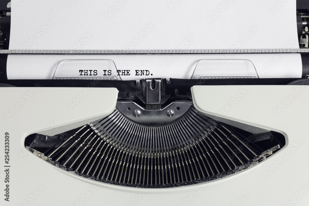 Fototapete Old retro obsolete white typewriter with close-up typing text This is the end as heading on paper